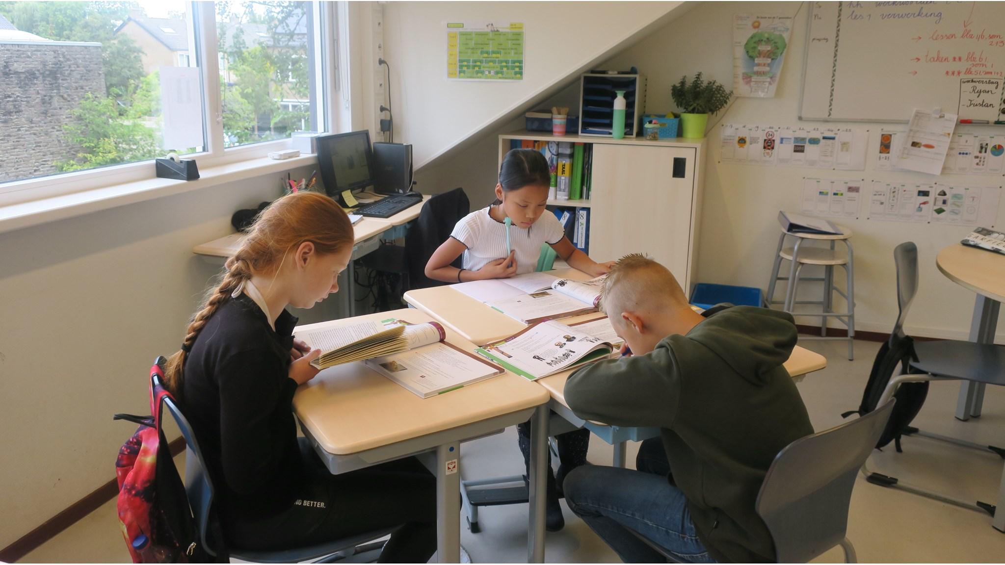 Leerlingen van school Drostenburg in Amsterdam zijn geconcentreerd aan het werk in de klas. Leerlingen van school Drostenburg in Amsterdam zijn geconcentreerd aan het werk in de klas.