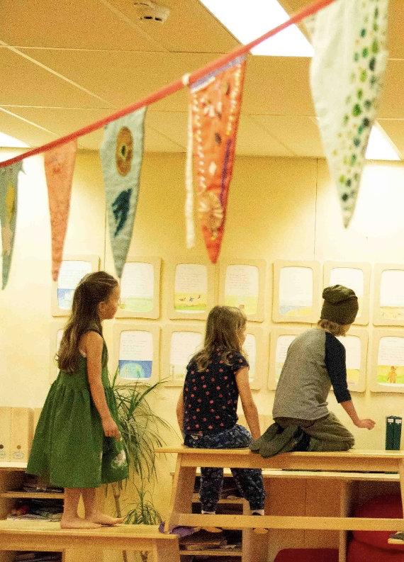 Leerlingen van Vrije School De Lindeboom in Haarlem bekijken werkstukken in een kleurrijke klasomgeving. Leerlingen van Vrije School De Lindeboom in Haarlem bekijken werkstukken in een kleurrijke klasomgeving.
