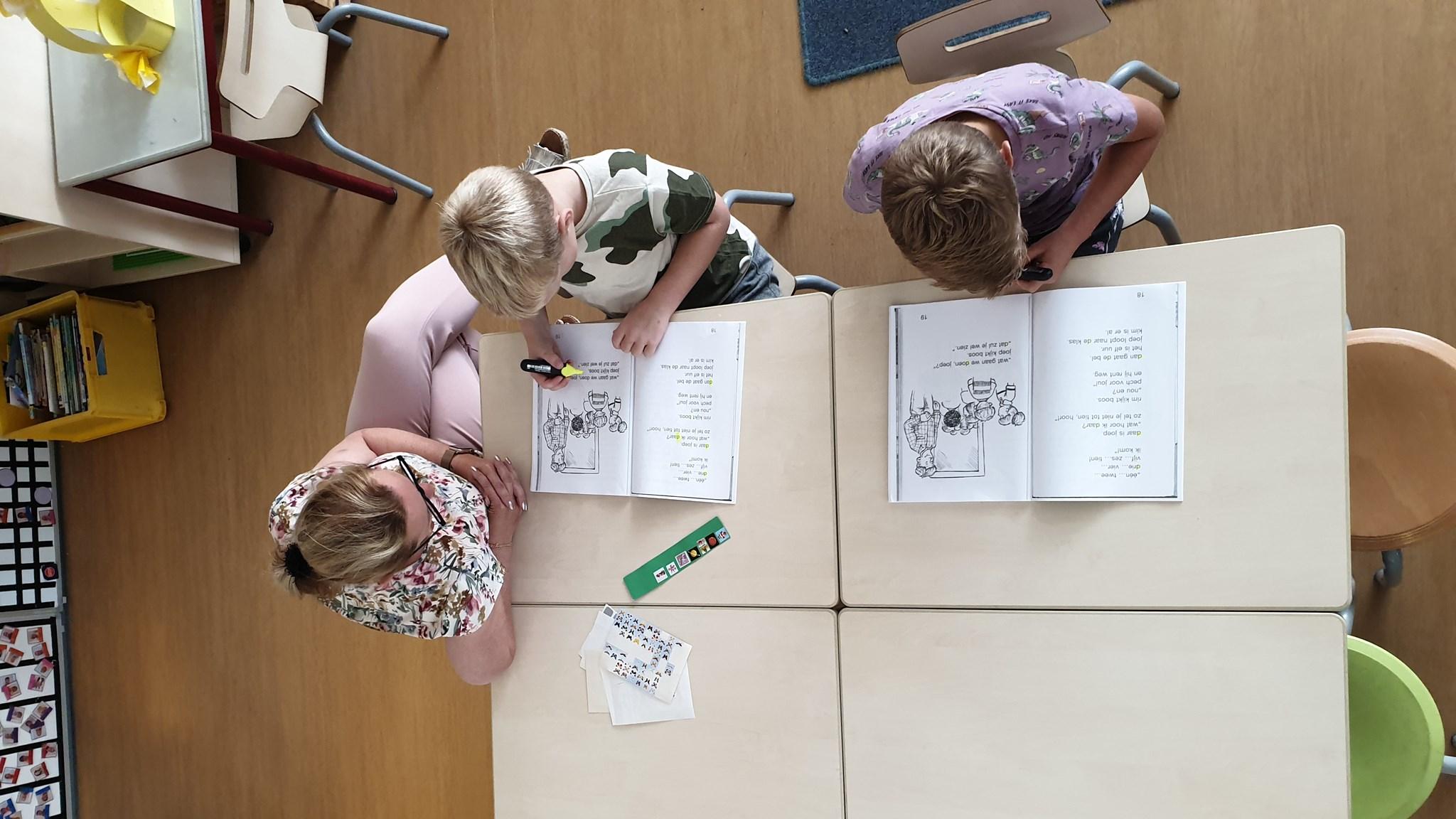 Leerlingen werken onder begeleiding van een docent aan hun werkboeken in Basisschool Maria in Erp. Leerlingen werken onder begeleiding van een docent aan hun werkboeken in Basisschool Maria in Erp.