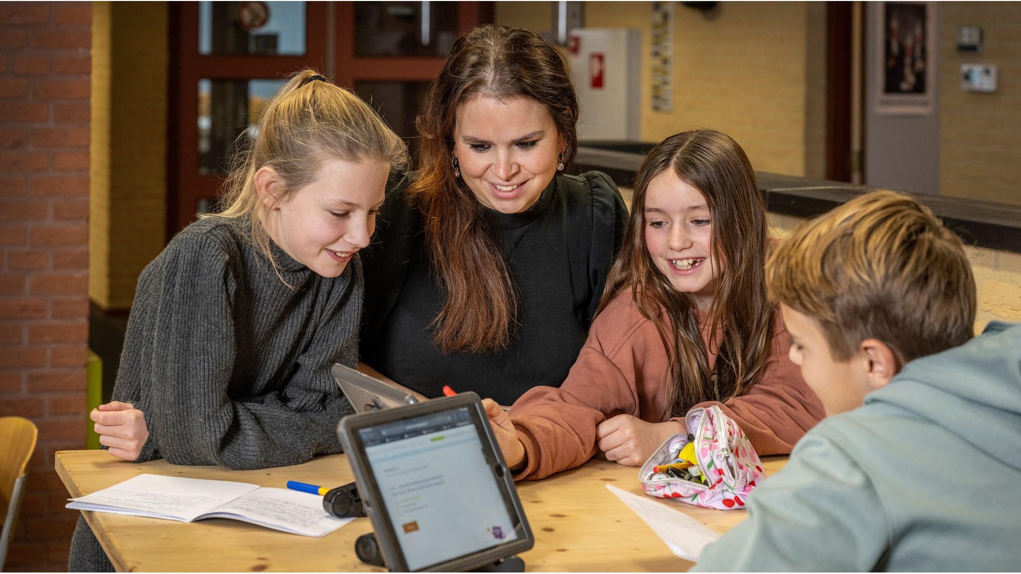 Leerlingen werken samen met een docente aan digitale opdrachten in KC LEEF in Kessel. Leerlingen werken samen met een docente aan digitale opdrachten in KC LEEF in Kessel.