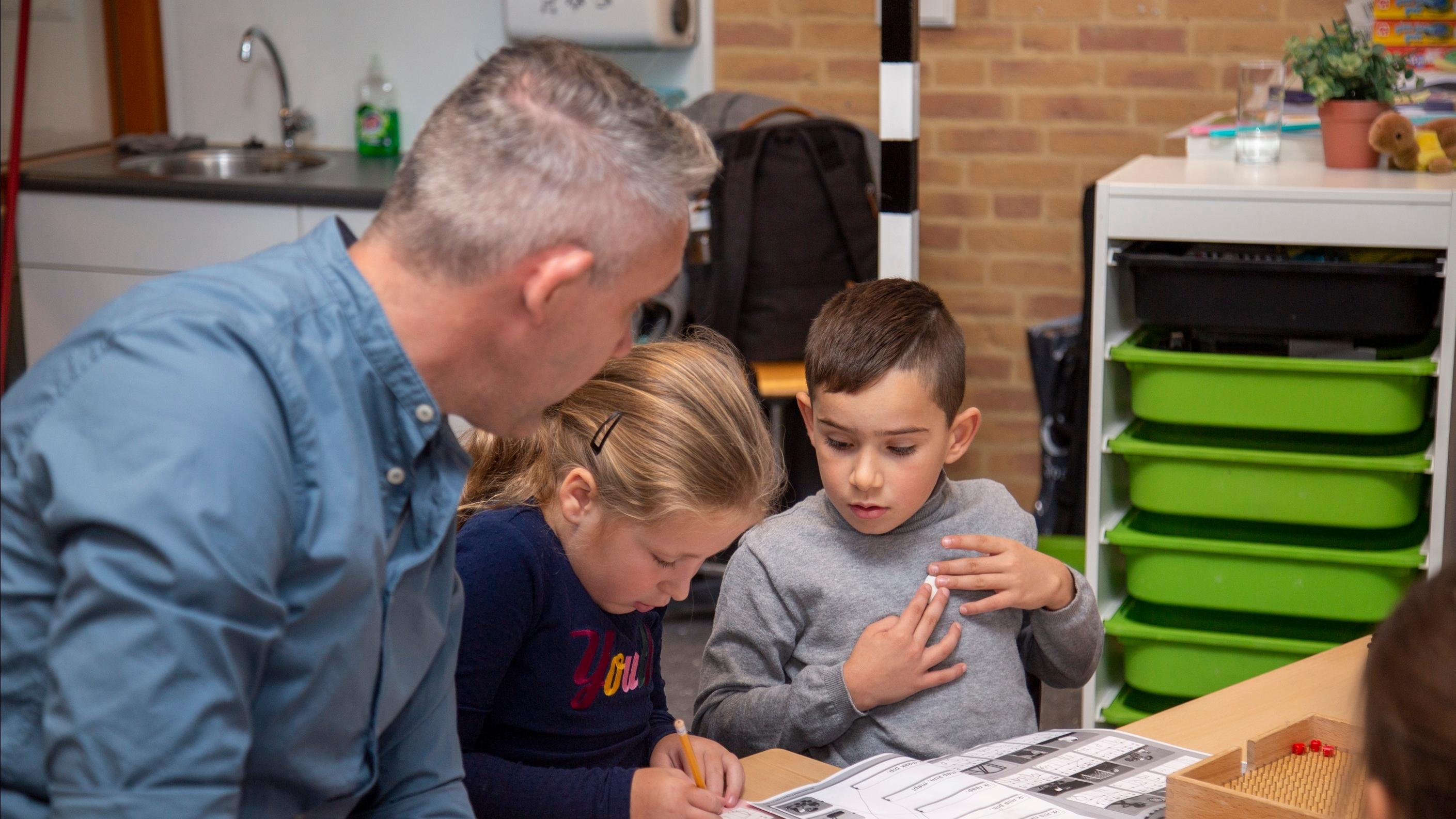 Leerlingen werken samen met een leerkracht aan een activiteit in de RK Basisschool Holtkamp in Goes. Leerlingen werken samen met een leerkracht aan een activiteit in de RK Basisschool Holtkamp in Goes.