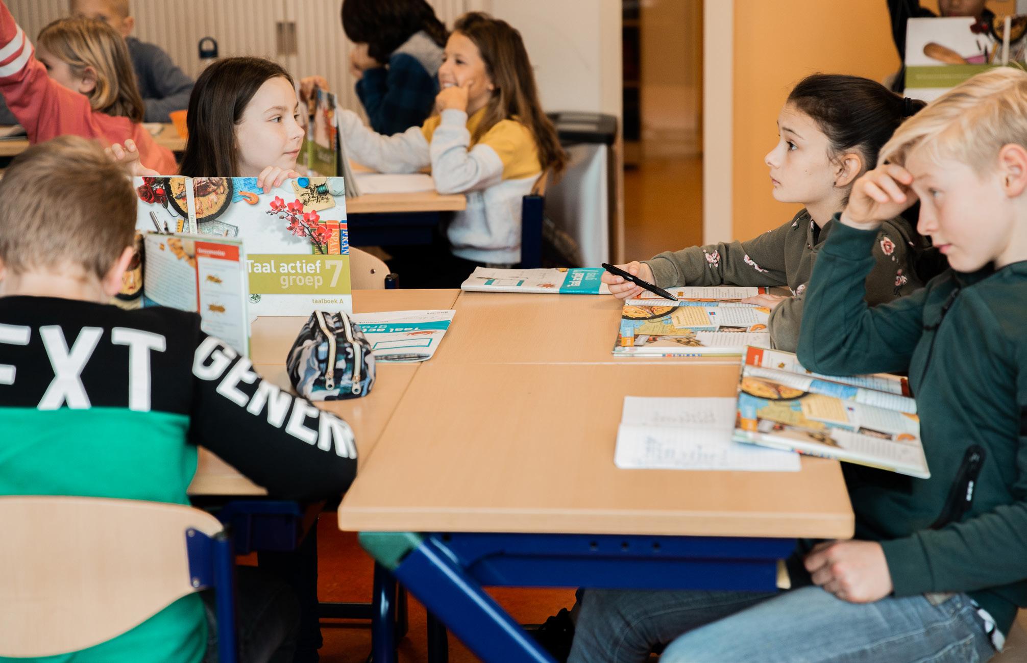 Leerlingen zijn actief bezig met hun lesmateriaal in de klas van de Paasbergschool in Ede.