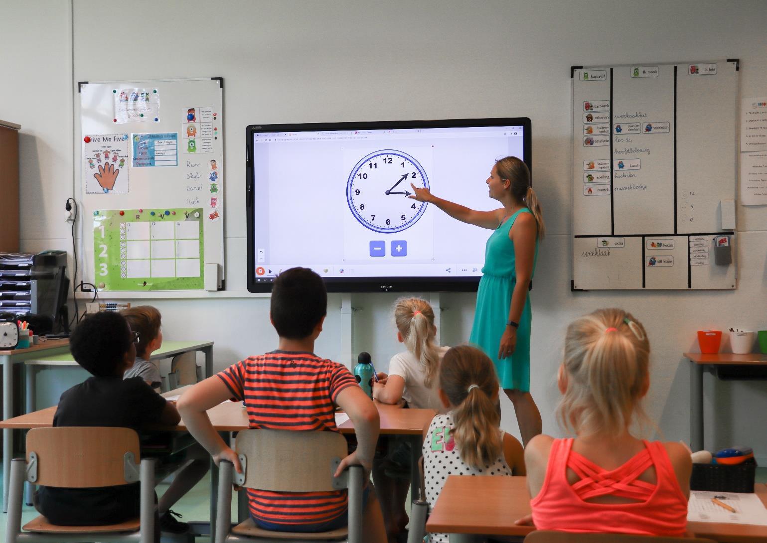 Lerares geeft uitleg over klokkijken aan leerlingen in de klas van obs De Bosrand in Oostvoorne. Lerares geeft uitleg over klokkijken aan leerlingen in de klas van obs De Bosrand in Oostvoorne.