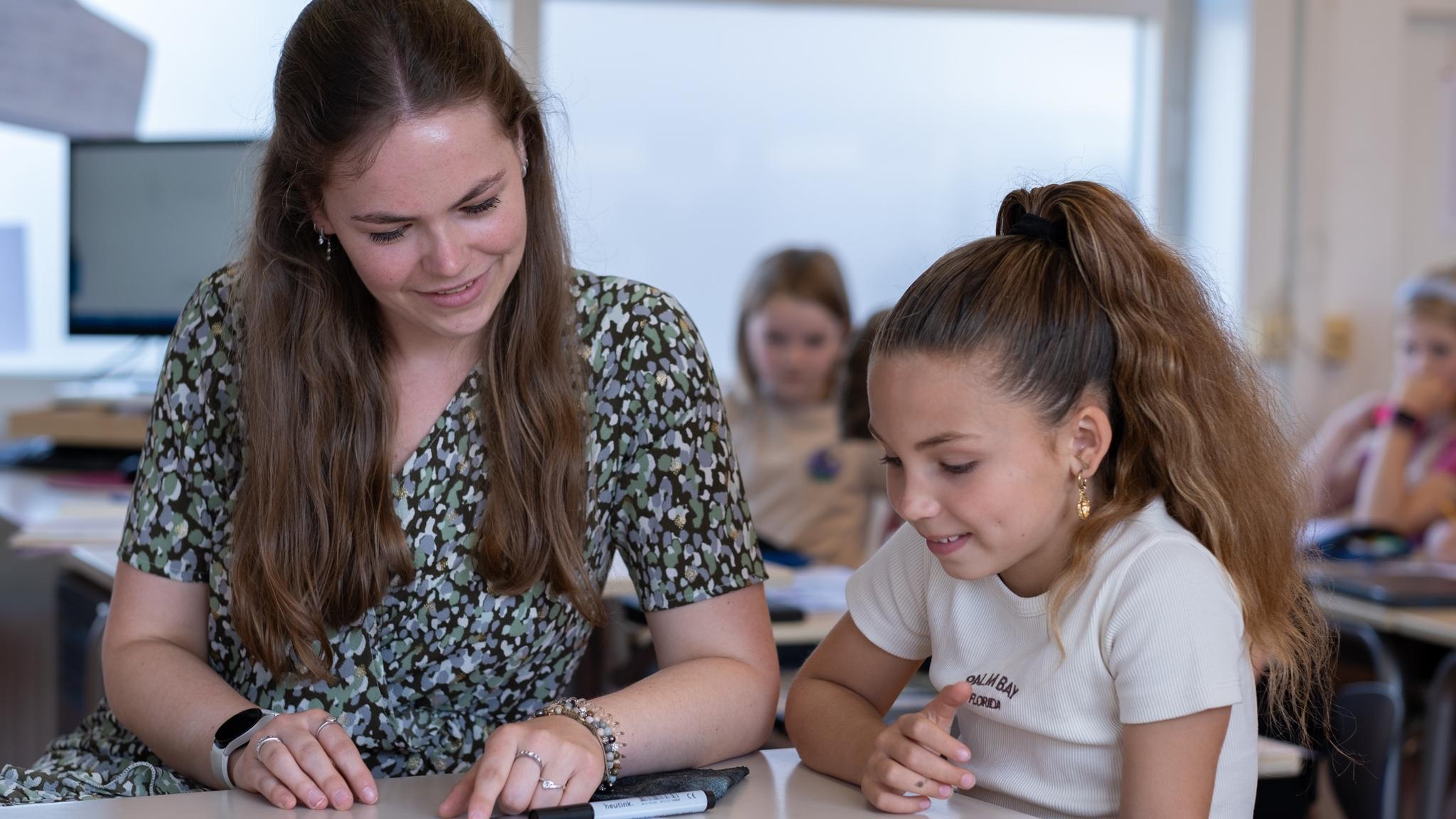 Lerares helpt een leerling met leren aan Basisschool Bonifatius in Enschede. Lerares helpt een leerling met leren aan Basisschool Bonifatius in Enschede.