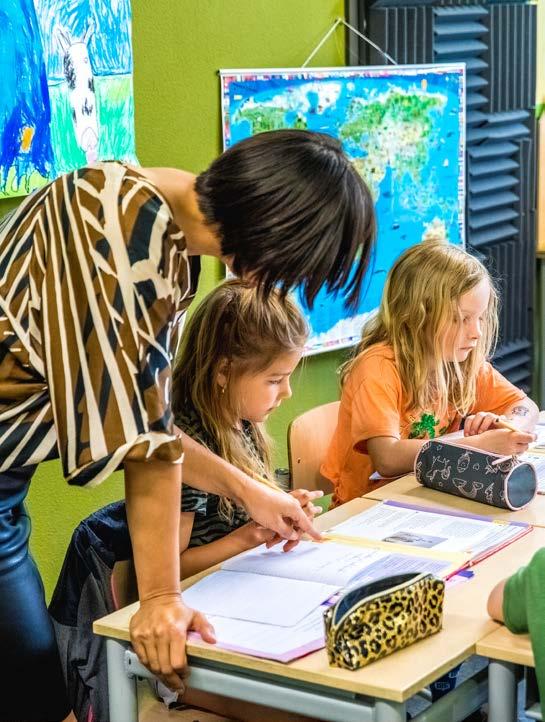 Lerares ondersteunt leerlingen bij hun werk in de klas van de Lorentzschool in Leiden. Lerares ondersteunt leerlingen bij hun werk in de klas van de Lorentzschool in Leiden.