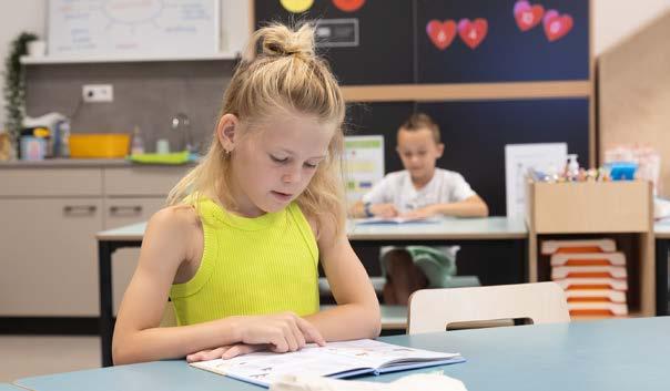 Meisje leest geconcentreerd in de klas van Christelijke Basisschool De Bron in Wezep.