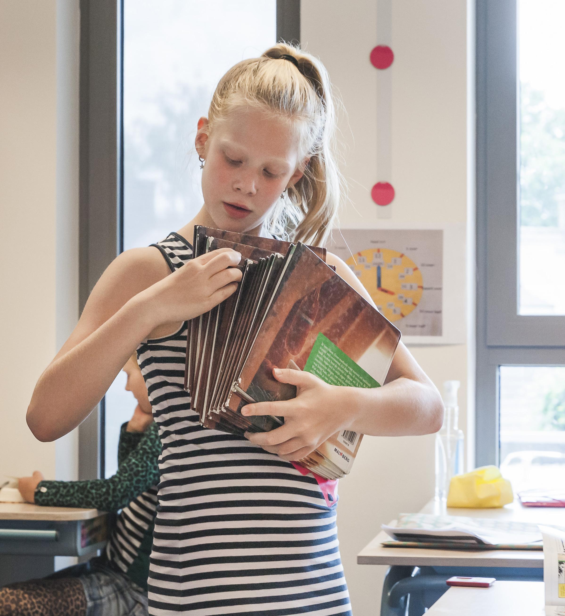 Meisje met boeken in de klas van Openbare Basisschool De Hasselbraam in Haaren. Meisje met boeken in de klas van Openbare Basisschool De Hasselbraam in Haaren.