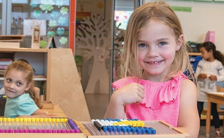 Meisje met een glimlach speelt met educatief speelgoed in de klas van OBS de Erasmus in Haarlem. Meisje met een glimlach speelt met educatief speelgoed in de klas van OBS de Erasmus in Haarlem.