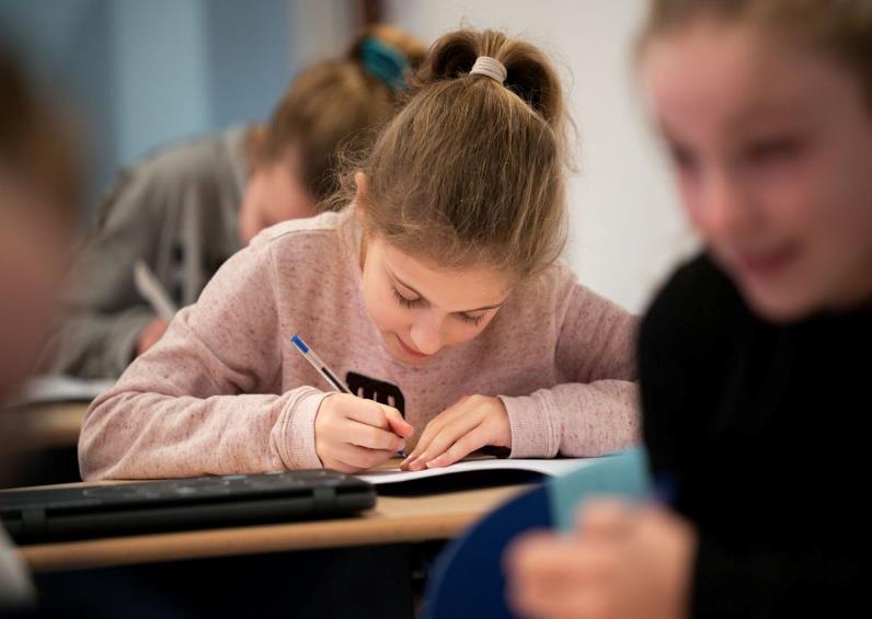 Meisjes aan CBS De Open Poort in Asperen zijn geconcentreerd aan het schrijven in de klas. Meisjes aan CBS De Open Poort in Asperen zijn geconcentreerd aan het schrijven in de klas.