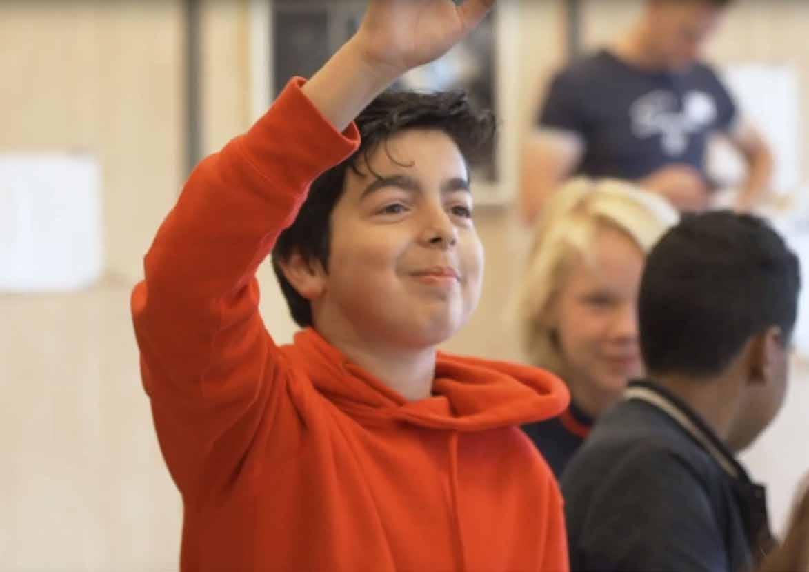 Montessori Campus 0-18 PO in Almere: Een leerling steekt zijn hand op in de klas. Montessori Campus 0-18 PO in Almere: Een leerling steekt zijn hand op in de klas.