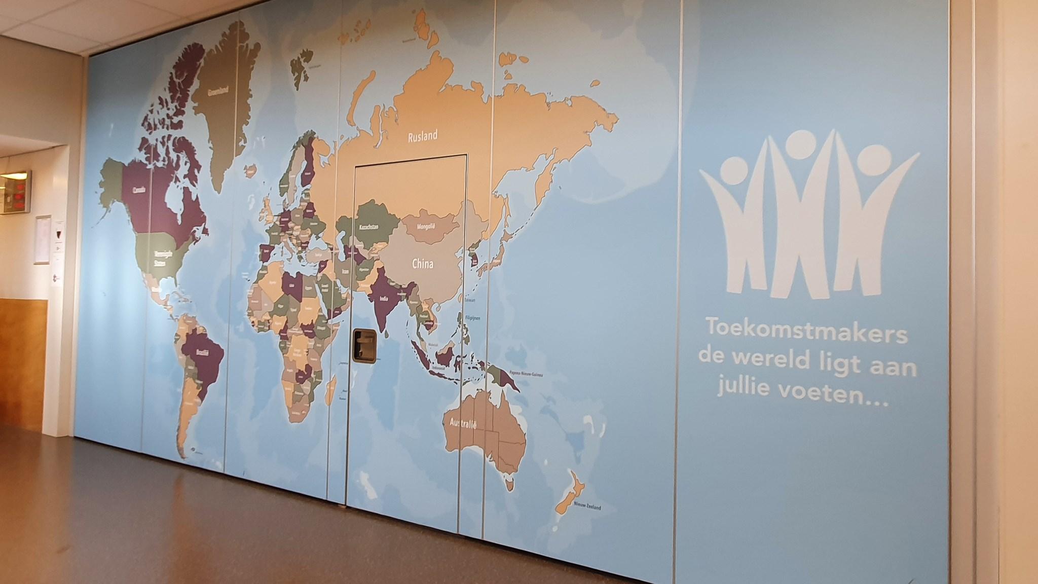 Muurkaart in Openbare Basisschool De Koningsspil in Oosthuizen, met de boodschap "Toekomstmakers, de wereld ligt aan jullie voeten..."