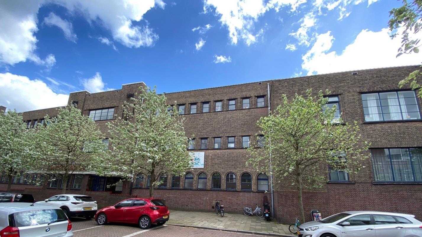 Nutsbasisschool Bezuidenhout in Den Haag, met bloeiende bomen en een heldere lucht op de achtergrond. Nutsbasisschool Bezuidenhout in Den Haag, met bloeiende bomen en een heldere lucht op de achtergrond.