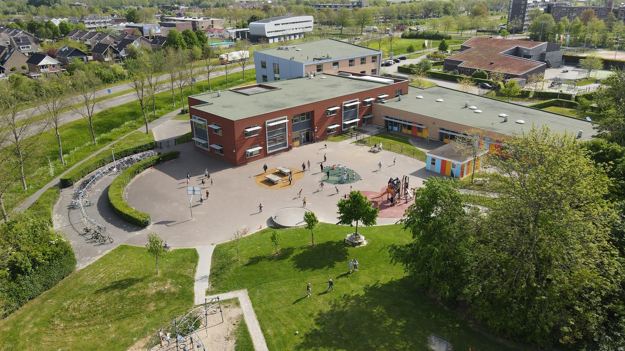 OBS De Opslach in Franeker, met kinderen die spelen op het schoolplein. OBS De Opslach in Franeker, met kinderen die spelen op het schoolplein.