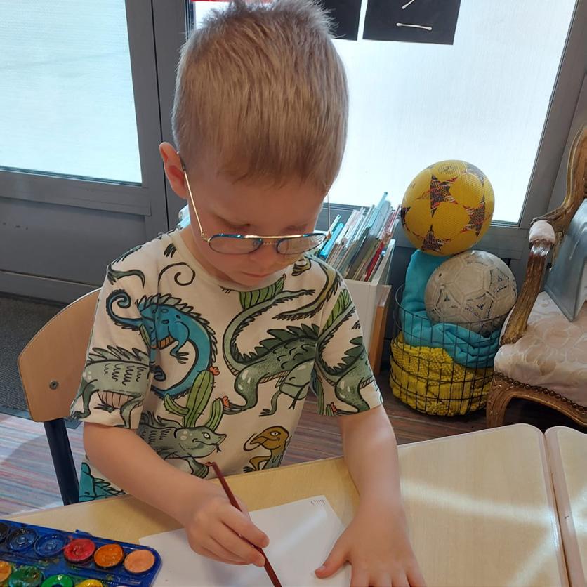 OBS Het Anker in Wijk bij Duurstede: Een kind met een dino shirt aan terwijl het zich concentreert op het tekenen met verf.