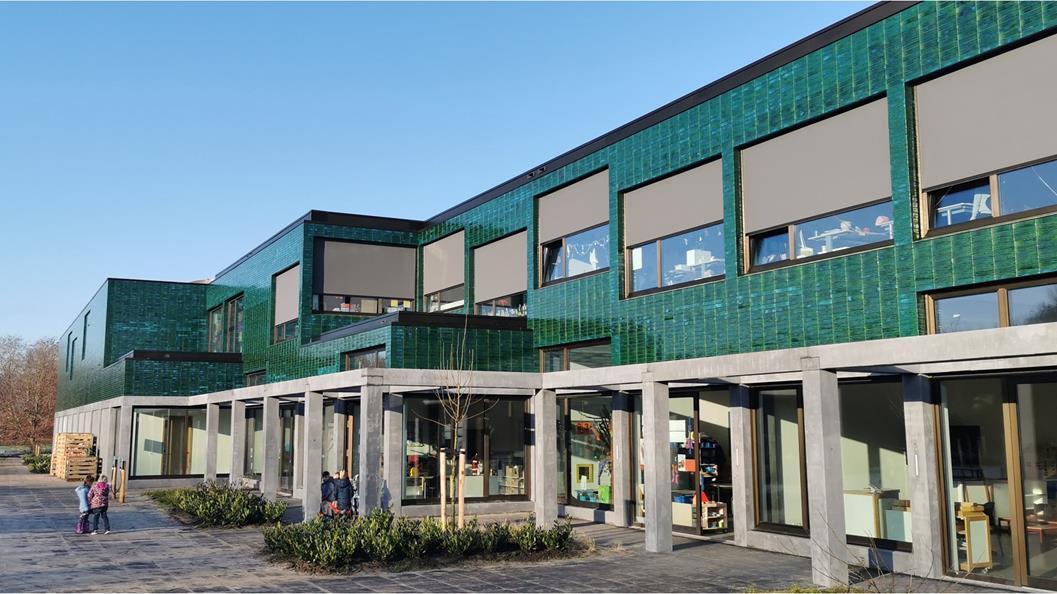 OBS Het Noorderlicht in Hoogezand, met een moderne groene gevel en kinderen op het schoolplein.