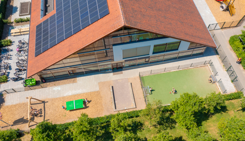 Op het schoolplein van Integraal Kindcentrum de Regenboog in Bemmel is een modern gebouw met zonnepanelen en speelplaatsen zichtbaar. Op het schoolplein van Integraal Kindcentrum de Regenboog in Bemmel is een modern gebouw met zonnepanelen en speelplaatsen zichtbaar.