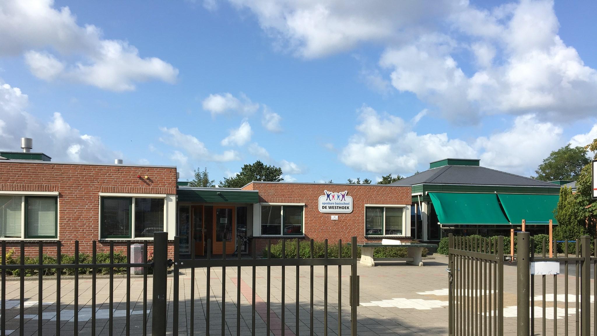 Openbare Basisschool De Westhoek in Ouddorp met een ruime toegangspoort en een zonnige speelplaats.