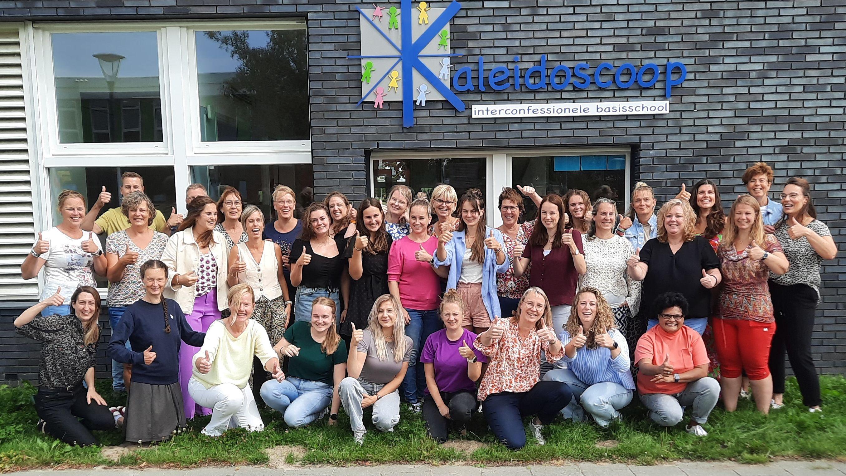 Personeel van basisschool Kaleidoscoop in Zeewolde posesert enthousiast voor het schoolgebouw. Personeel van basisschool Kaleidoscoop in Zeewolde posesert enthousiast voor het schoolgebouw.