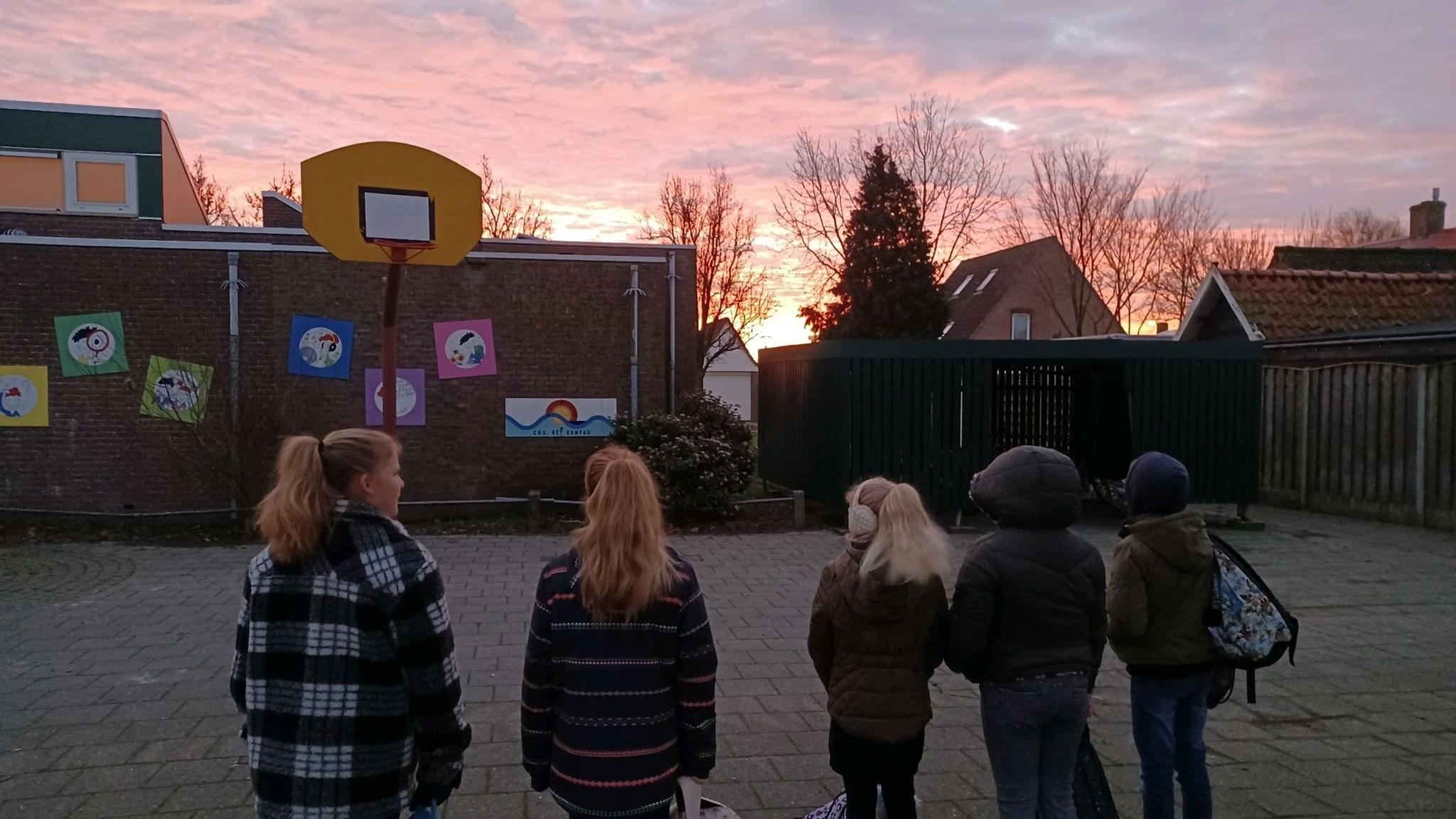 Scholen op het schoolplein van Christelijke Basisschool Het Kompas in Sint Philipsland tijdens een prachtige zonsondergang. Scholen op het schoolplein van Christelijke Basisschool Het Kompas in Sint Philipsland tijdens een prachtige zonsondergang.