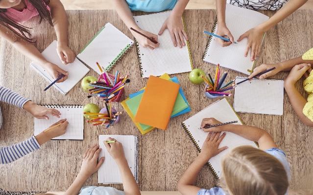Scholieren van Openbare Basisschool Het Wooldrik in Enschede zijn actief bezig met tekenen en schrijven aan een tafel. Scholieren van Openbare Basisschool Het Wooldrik in Enschede zijn actief bezig met tekenen en schrijven aan een tafel.