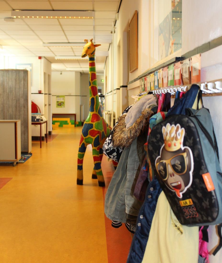 School voor Speciaal Basisonderwijs Dr JP Heije in Hoofddorp, met kleurrijke jassen en een giraffe in de gang.