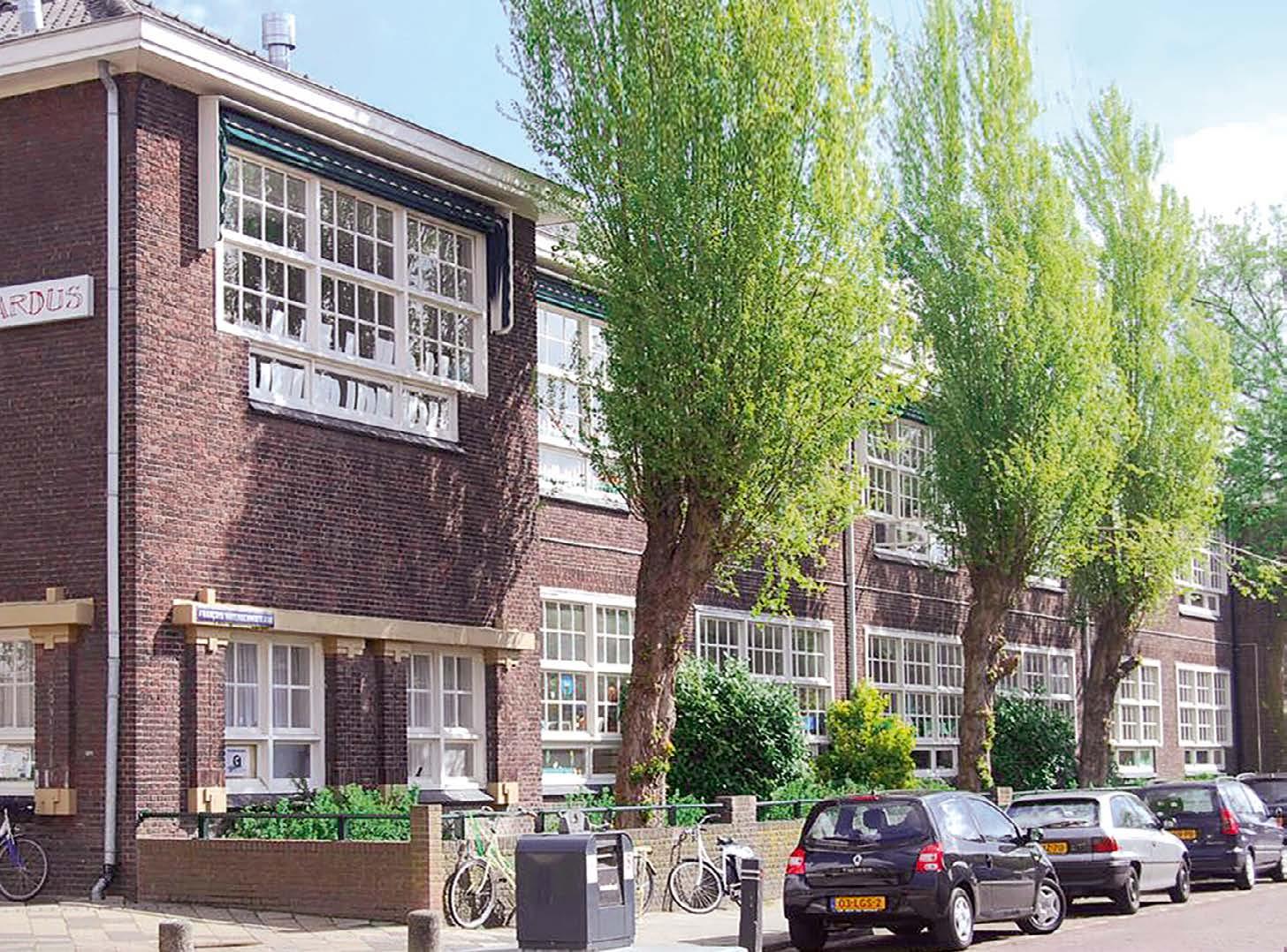 Schoolgebouw van Avonturijn in Vlaardingen met groene bomen en omliggende fietsen. Schoolgebouw van Avonturijn in Vlaardingen met groene bomen en omliggende fietsen.