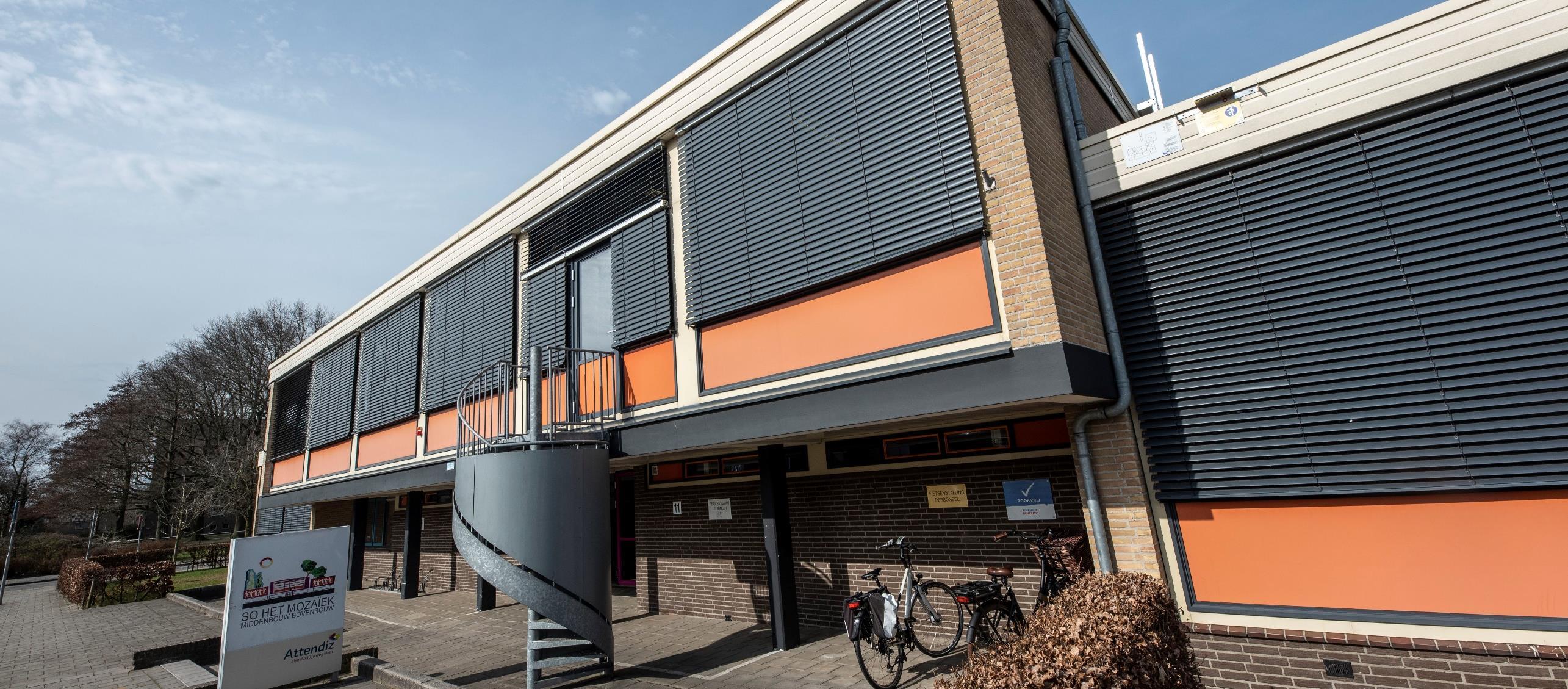 Schoolgebouw van het Mozaïek in Almelo met een spiralen trap en fietsen voor de ingang. Schoolgebouw van het Mozaïek in Almelo met een spiralen trap en fietsen voor de ingang.