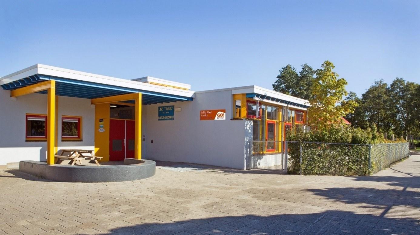 Schoolgebouw van IKC de Tjalk in Lelystad met een kleurrijke entree en een schoolplein.