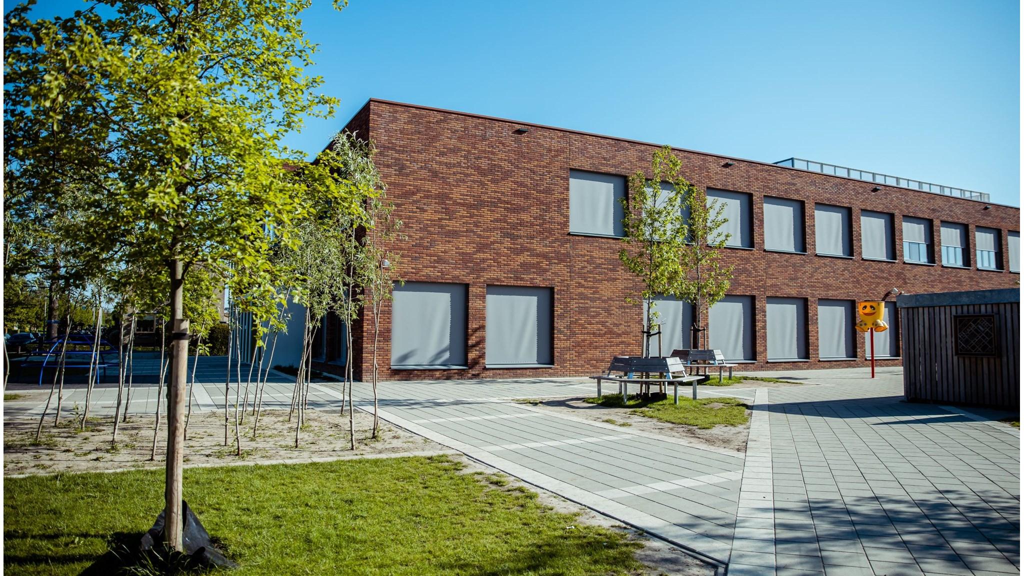 Schoolgebouw van SmdB De Kandelaar in Ameide met een groene schoolplein.