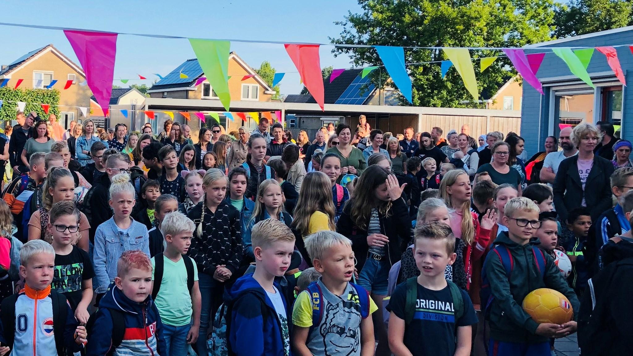 Schoolplein met kinderen en ouders tijdens een evenement bij Skoalle de Sinnewizer in Wijnjewoude. Schoolplein met kinderen en ouders tijdens een evenement bij Skoalle de Sinnewizer in Wijnjewoude.
