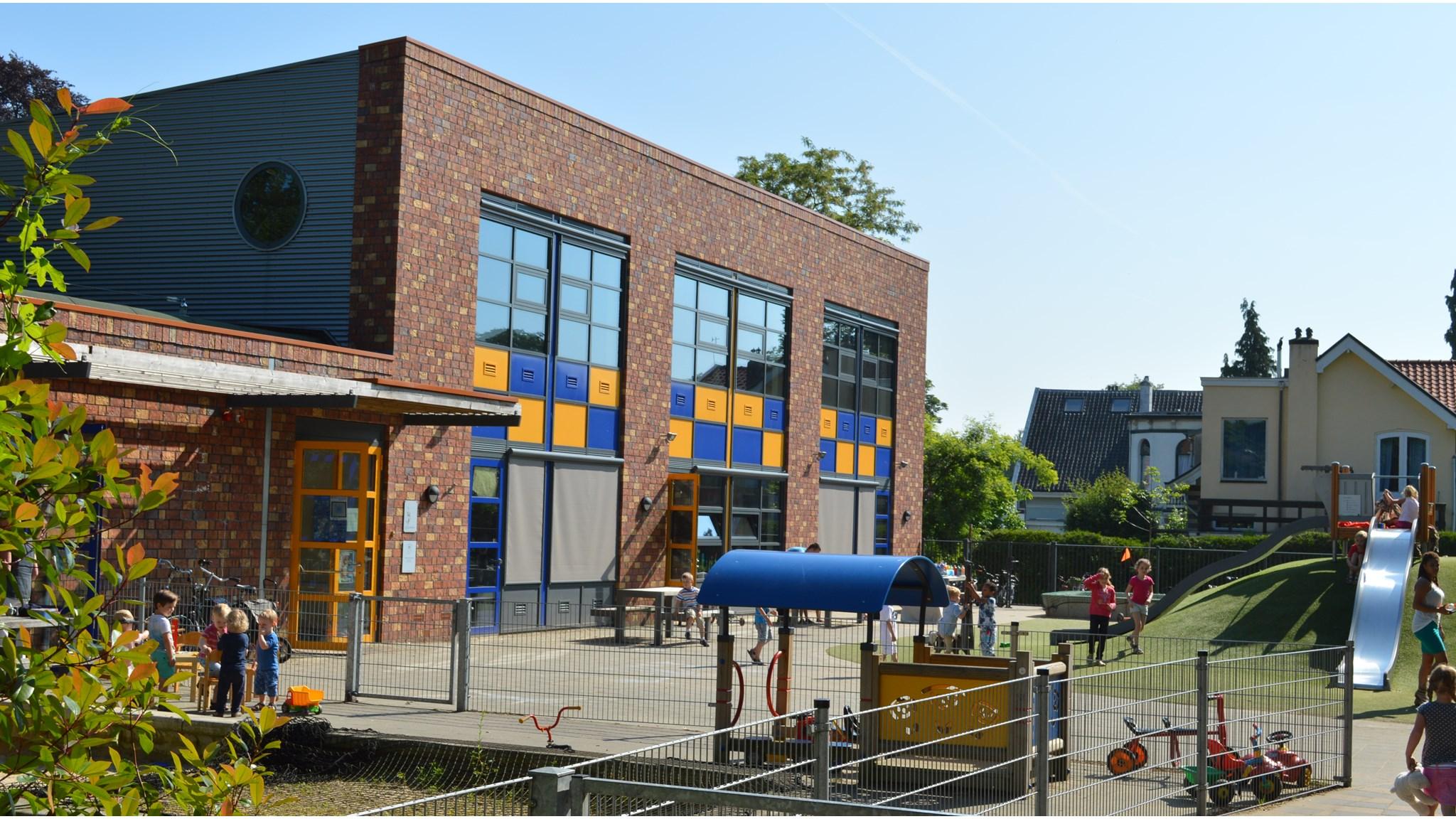 Schoolplein van Basisschool de Paasberg in Oosterbeek met kinderen die spelen.