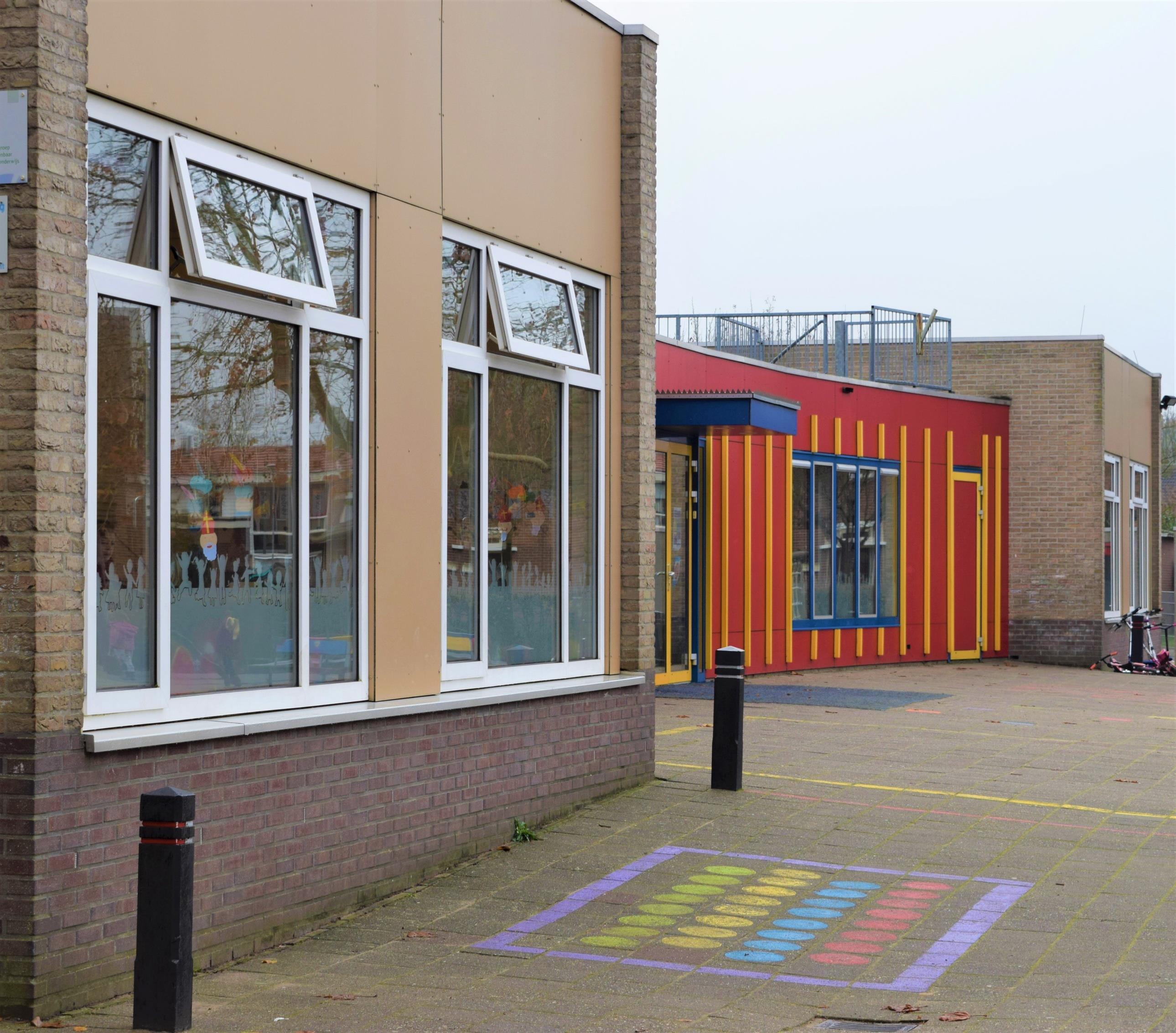 Schoolplein van Basisschool Jan Ligthart in Zelhem met kleurrijke speeltuin en schoolgebouwen.