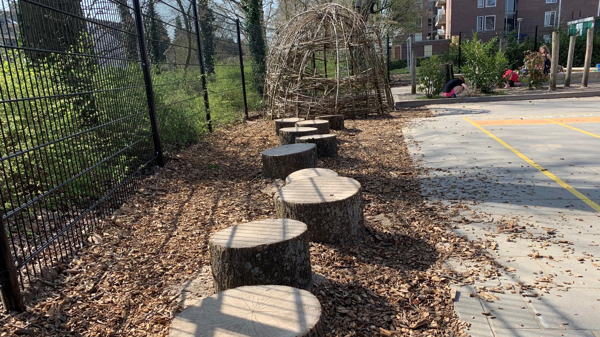 Schoolplein van Basisschool Kameleon in Goirle met houten stammetjes en een natuurlijke speelomgeving. Schoolplein van Basisschool Kameleon in Goirle met houten stammetjes en een natuurlijke speelomgeving.