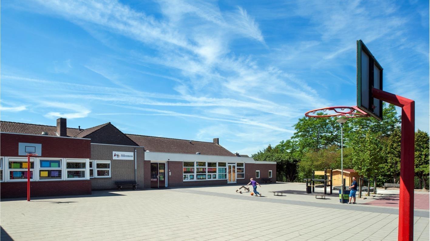 Schoolplein van Basisschool Ondersteboven in Moorveld met een basketbalring en kinderen die spelen. Schoolplein van Basisschool Ondersteboven in Moorveld met een basketbalring en kinderen die spelen.