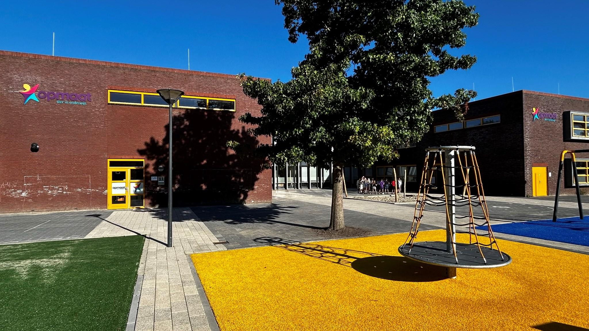 Schoolplein van basisschool Opmaat in Nieuw-Vennep met kleurrijke speeltoestellen en moderne gebouwen.