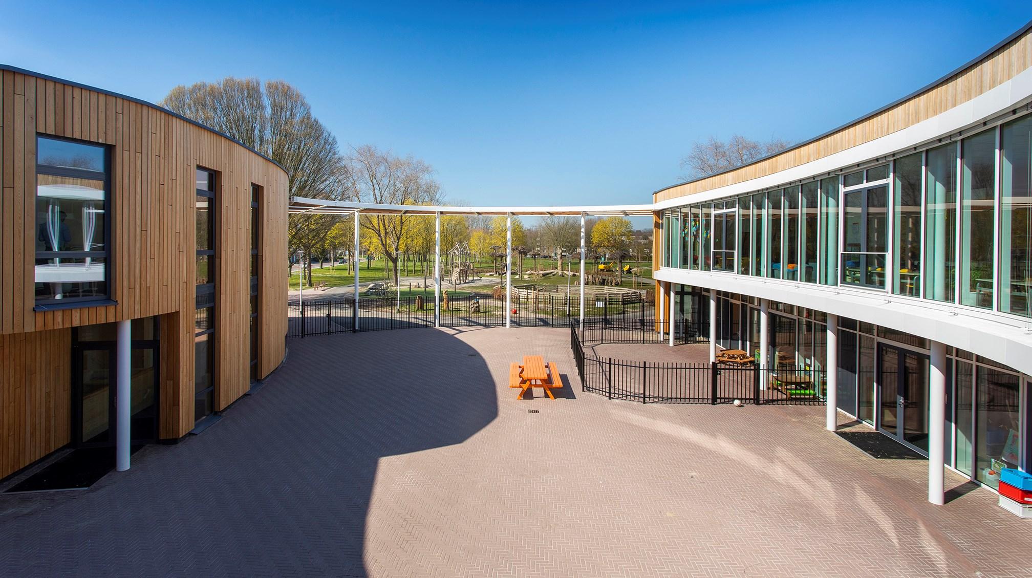 Schoolplein van Basisschool Wonderwijs in Hoensbroek met modern gebouw en speeltoestellen. Schoolplein van Basisschool Wonderwijs in Hoensbroek met modern gebouw en speeltoestellen.