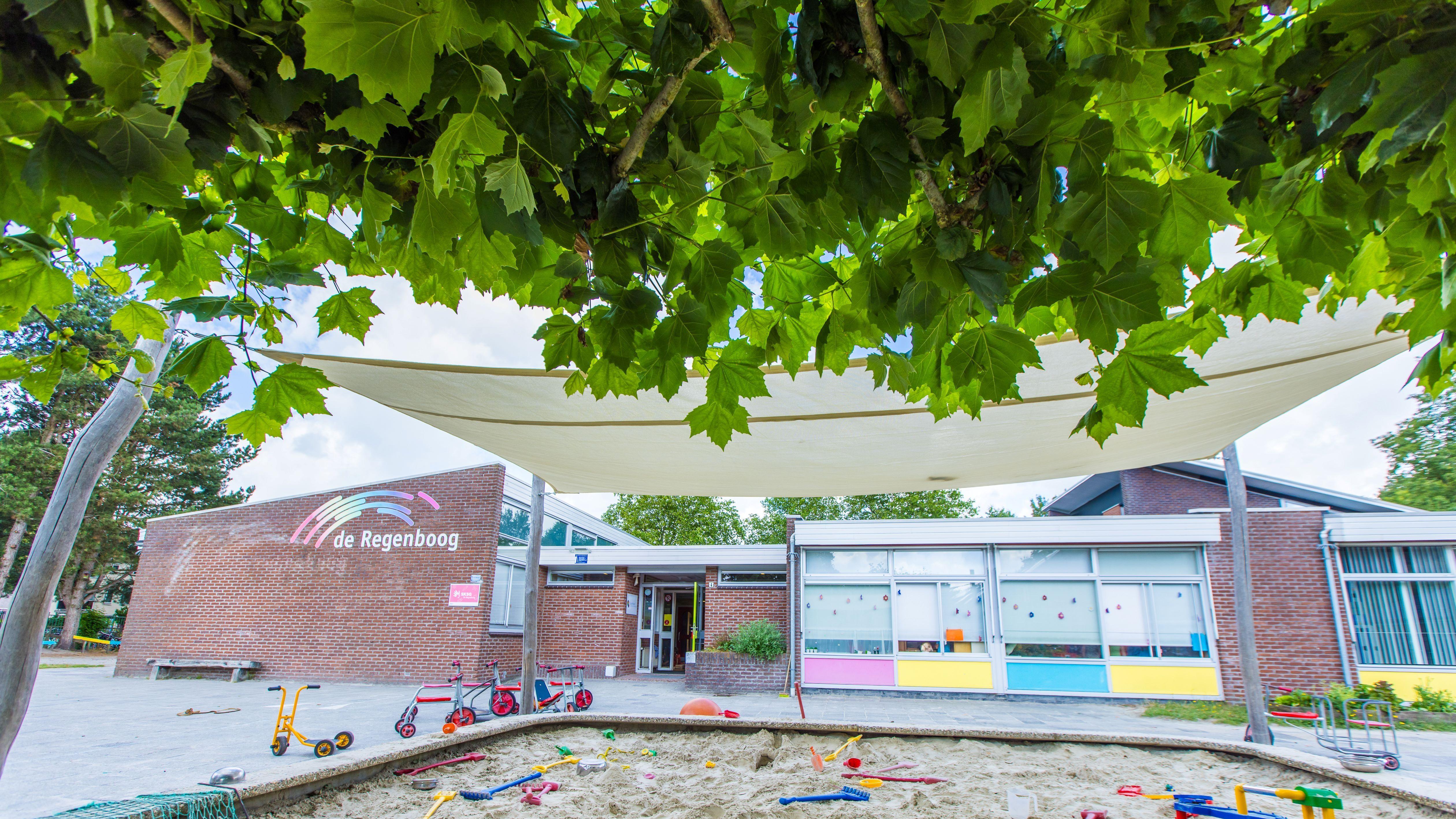 Schoolplein van CBS de Regenboog in Tolbert met speelmateriaal en een zonnenscherm. Schoolplein van CBS de Regenboog in Tolbert met speelmateriaal en een zonnenscherm.