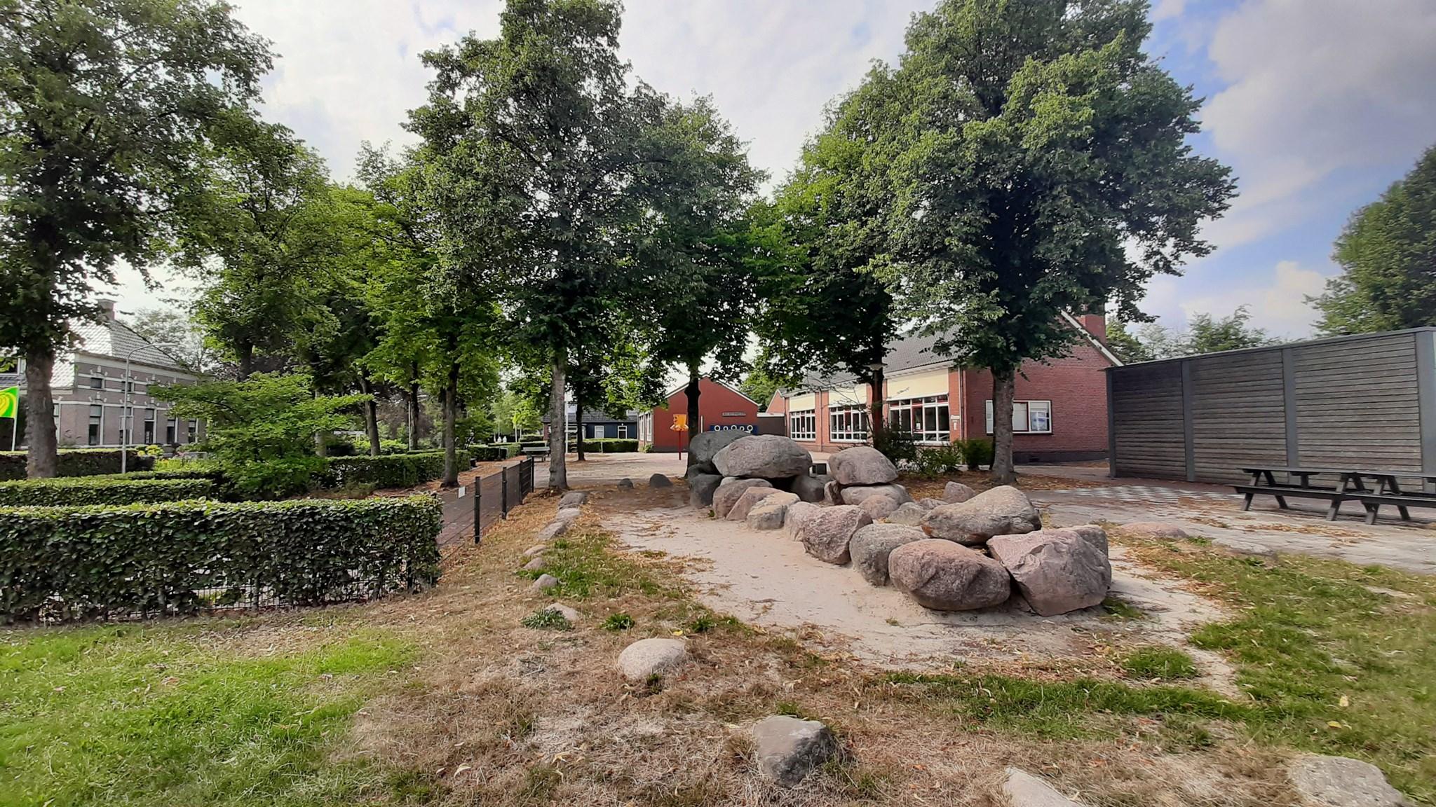 Schoolplein van de Bonnerschool in Gieten, omringd door groene bomen en stenen. Schoolplein van de Bonnerschool in Gieten, omringd door groene bomen en stenen.