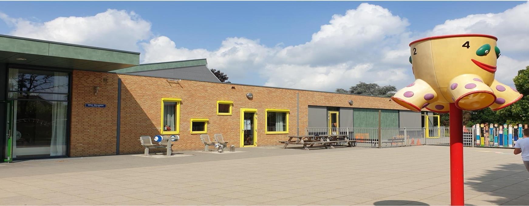 Schoolplein van de Grasspriet in Valkenswaard met een kleurrijk speeltuig en een moderne gevel. Schoolplein van de Grasspriet in Valkenswaard met een kleurrijk speeltuig en een moderne gevel.