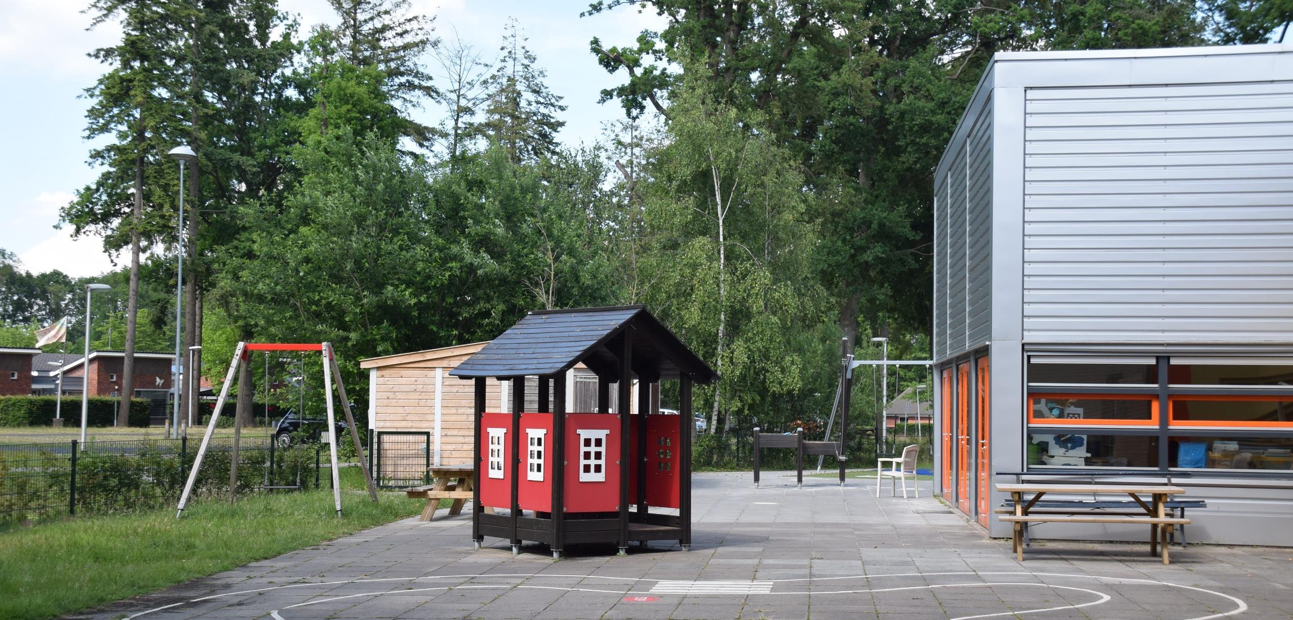 Schoolplein van De Meander in Losser met speeltoestellen en groen landschap.