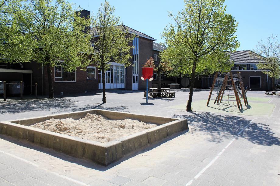 Schoolplein van de School voor Speciaal Basisonderwijs Dr JP Heije in Hoofddorp met zandbak en speeltoestellen.