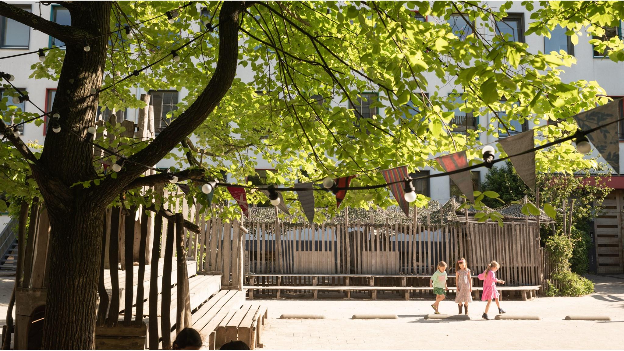 Schoolplein van IKC De Kleine Reus in Amsterdam met speeltuin en kinderen die spelen. Schoolplein van IKC De Kleine Reus in Amsterdam met speeltuin en kinderen die spelen.