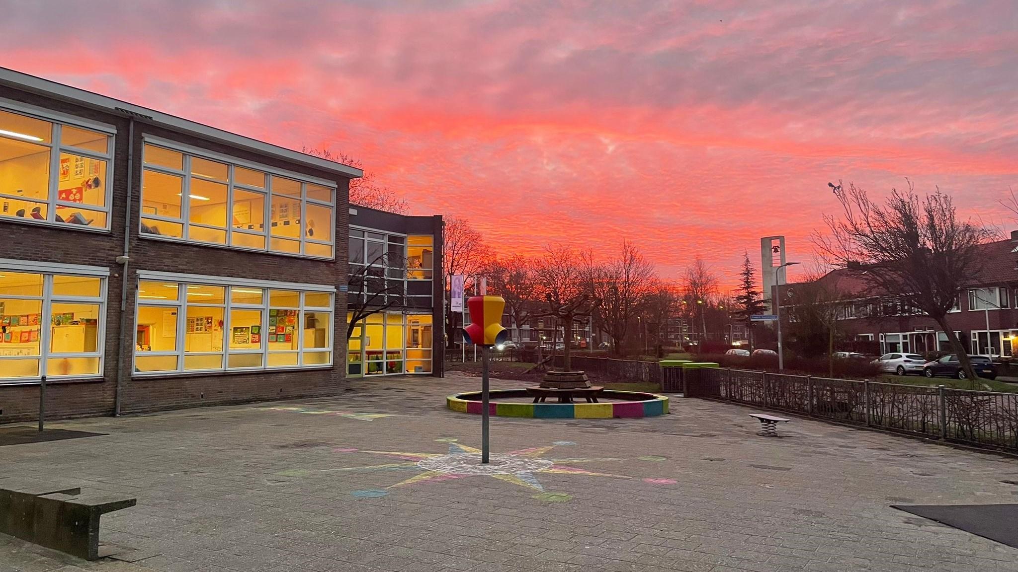Schoolplein van IKC Franciscus in Leeuwarden met een kleurrijke lucht bij zonsondergang. Schoolplein van IKC Franciscus in Leeuwarden met een kleurrijke lucht bij zonsondergang.