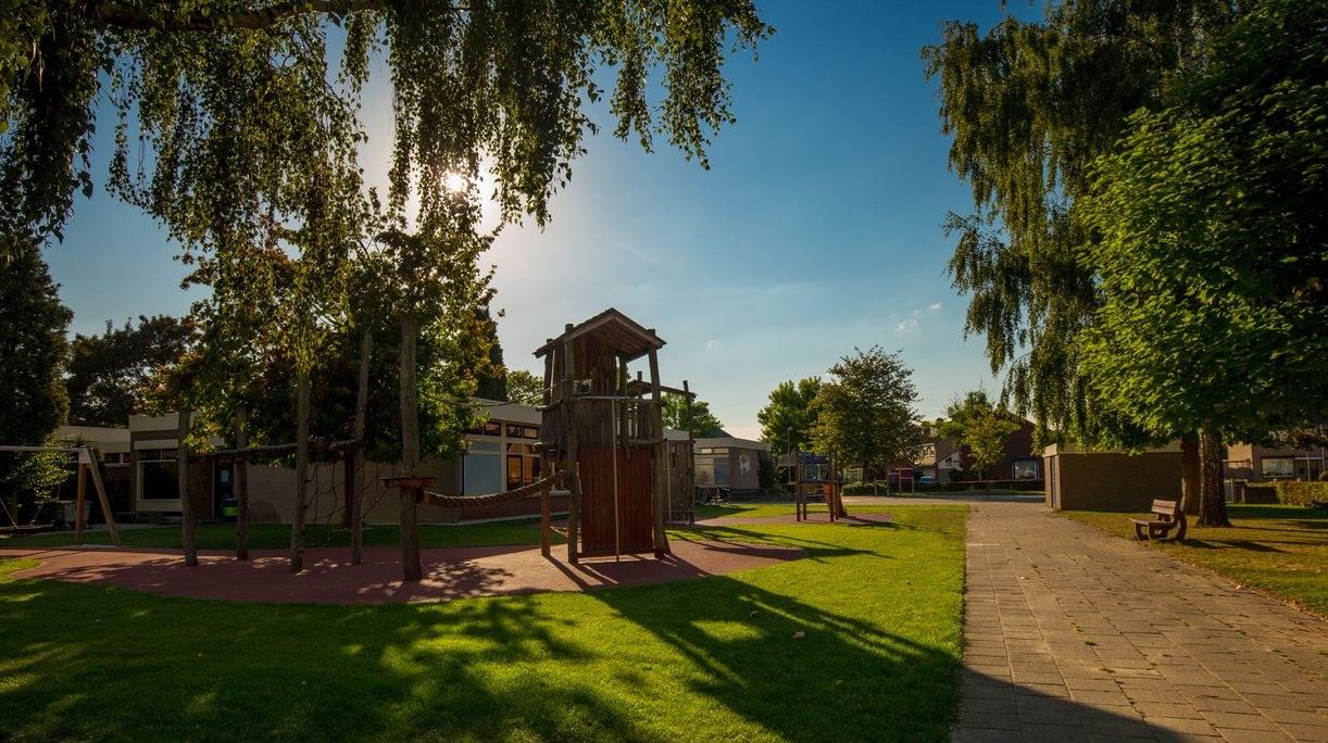 Schoolplein van IKC Sprankel in Herwen met speeltoestellen en groenrijke omgeving. Schoolplein van IKC Sprankel in Herwen met speeltoestellen en groenrijke omgeving.