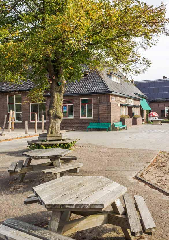Schoolplein van Kindcentrum De Vossestaart in Hall met picknicktafels en een boom. Schoolplein van Kindcentrum De Vossestaart in Hall met picknicktafels en een boom.