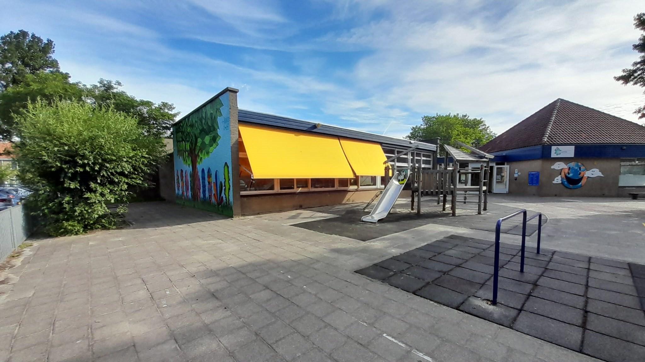 Schoolplein van Openbare Basisschool De Piramide in Edam met kleurrijke mu mural en speeltoestellen. Schoolplein van Openbare Basisschool De Piramide in Edam met kleurrijke mu mural en speeltoestellen.