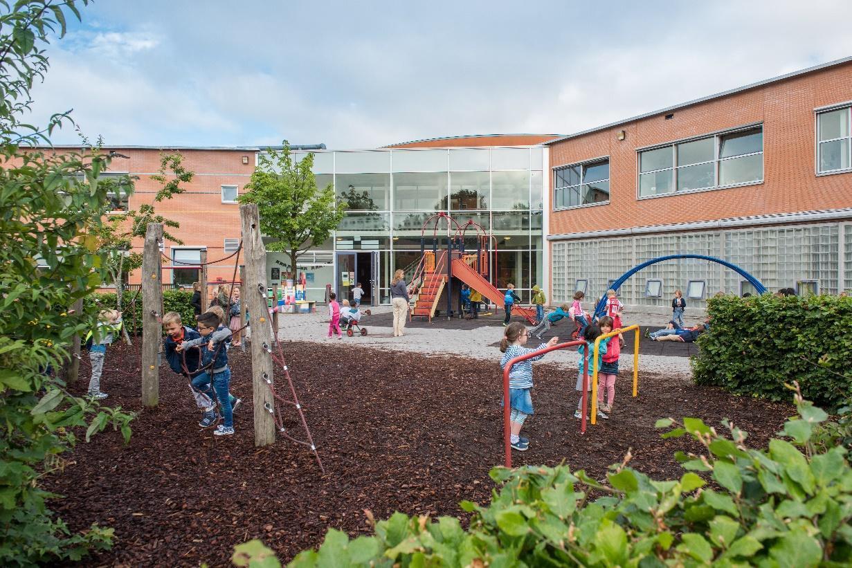 Schoolplein van Piet Mondriaan in Abcoude met spelende kinderen en een speelmolen. Schoolplein van Piet Mondriaan in Abcoude met spelende kinderen en een speelmolen.