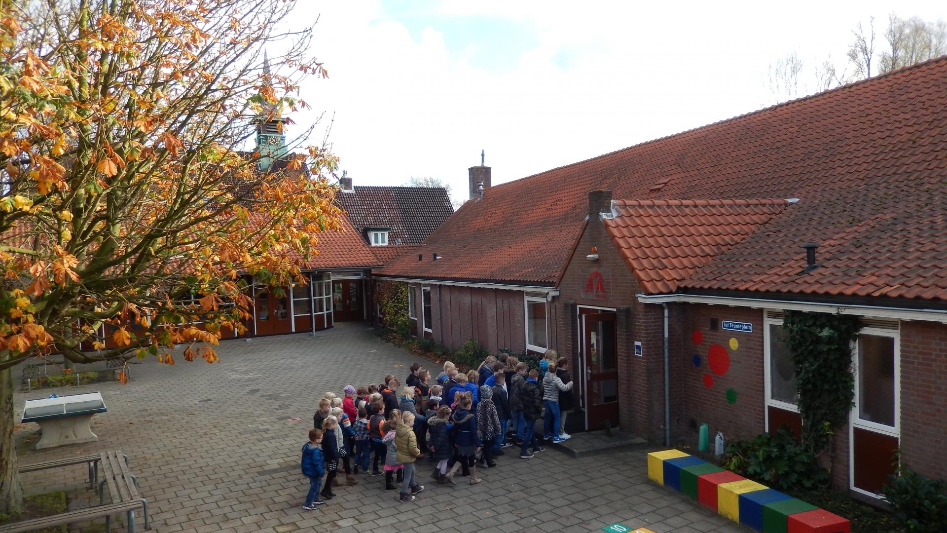 Schoolplein van Rooms Katholieke basisschool St. Willibrordus in Buitenkaag met kinderen die naar binnen gaan. Schoolplein van Rooms Katholieke basisschool St. Willibrordus in Buitenkaag met kinderen die naar binnen gaan.