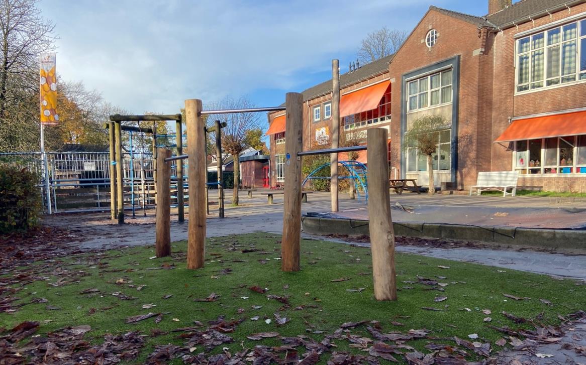 Speelplaats van de Christelijke Nationale School De Bijenschans in Breukelen met houten speeltoestellen en een groene ondergrond. Speelplaats van de Christelijke Nationale School De Bijenschans in Breukelen met houten speeltoestellen en een groene ondergrond.