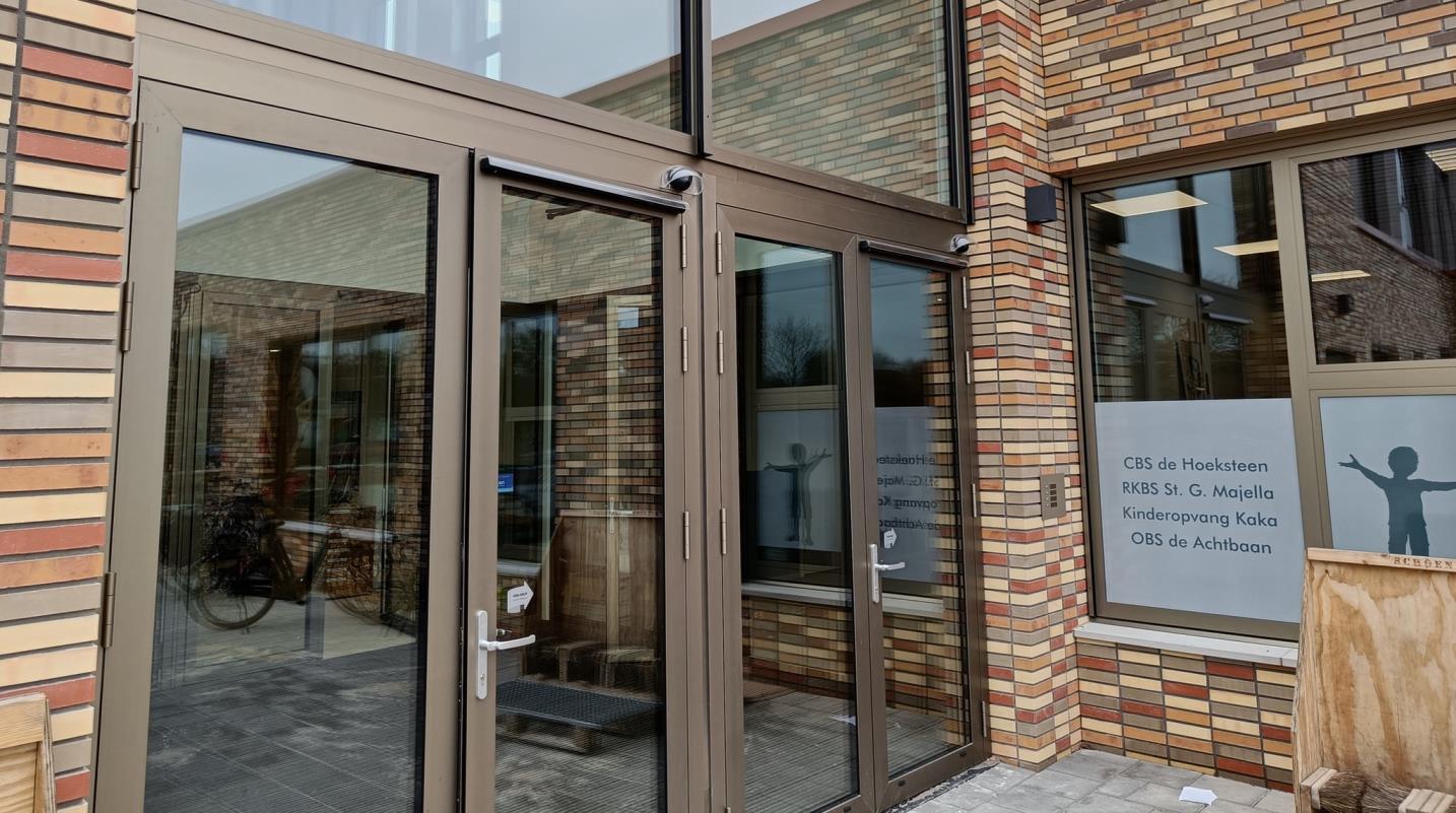 Toegang tot OBS de Achtbaan in Hoogezand met moderne glasdeuren en bakstenen gevel. Toegang tot OBS de Achtbaan in Hoogezand met moderne glasdeuren en bakstenen gevel.